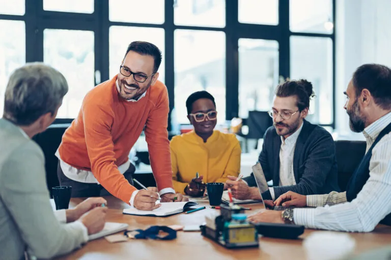 Multiracial group of business persons sitting around a table and talking